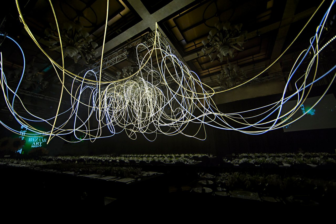 Grimanesa Amorós GOLDEN CONNECTION, two-part LED sculpture and light sculpture at the Four Seasons Hotel Grand Ballroom, Harper's BAZAAR Art Night, Art Basel Hong Kong, 2013. A 100 x 50 x 20-foot ballroom LED ceiling installation and a 9 x 8 x 12-foot foyer light sculpture in stainless steel, diffusion and reflective material, and LEDs, celebrating the inaugural Art Basel Hong Kong under the theme "Art Changes the World." Light sculpture by Grimanesa Amorós.