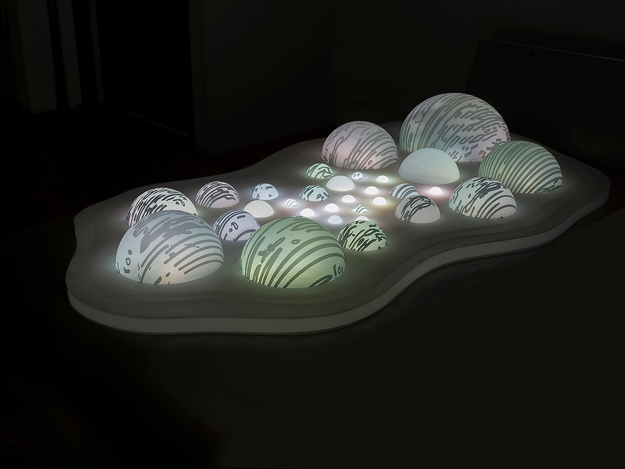 Grimanesa Amorós LIGHT BETWEEN THE ISLANDS #4, 47 x 84 x 16-inch light sculpture made of LEDs, diffusion material, and custom lighting sequence, featuring glowing domes as islands of varying sizes with illuminated interiors, transmitting a feeling of temporariness, magic, and wonder while meditating on memory, sites, and landscapes. Light sculpture by Grimanesa Amorós, 2013.
