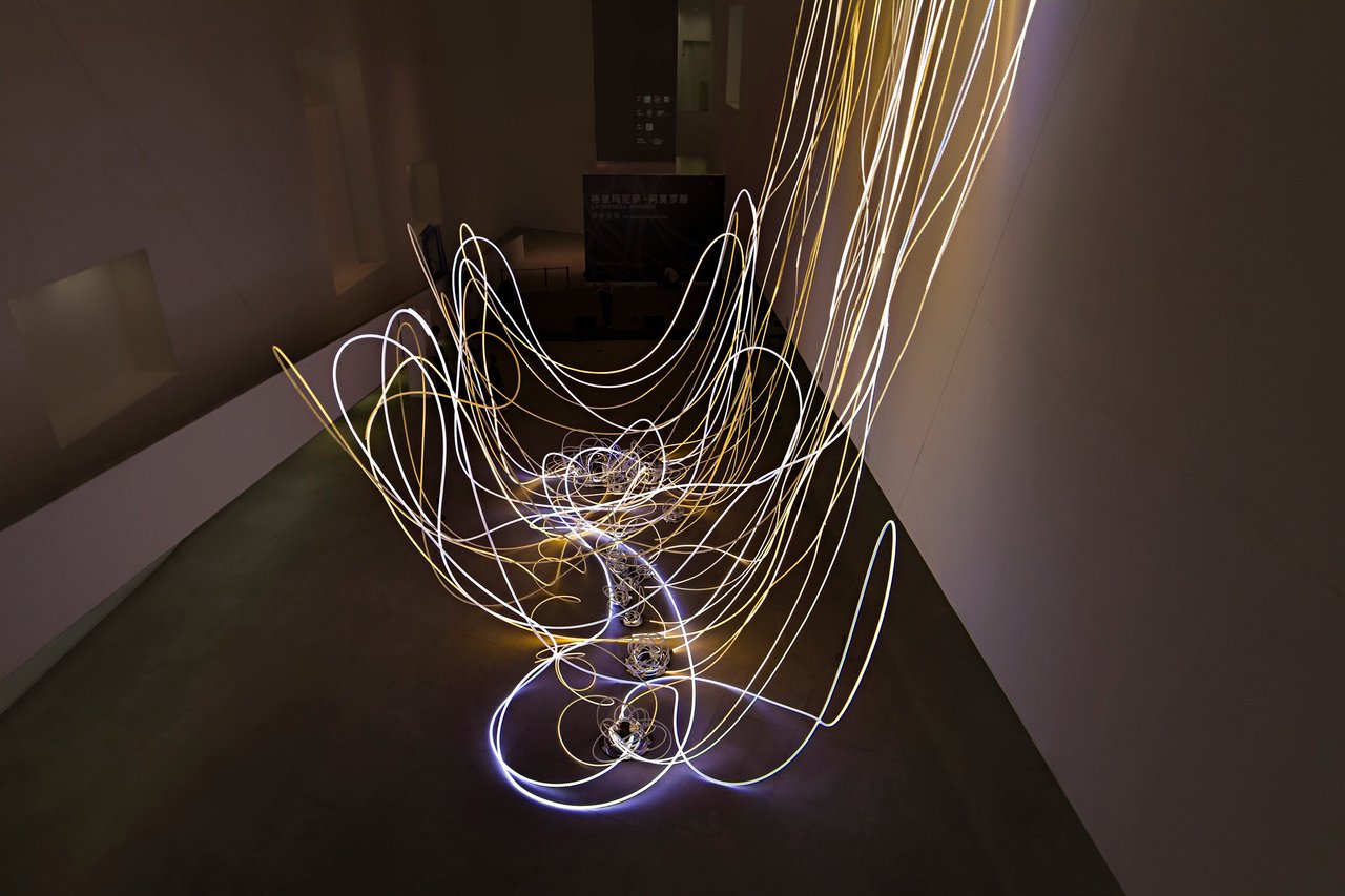 Grimanesa Amorós THE MIRROR CONNECTION, 90 x 70 x 40-foot LED sculpture and light sculpture made of mixed media, LEDs, diffusive reflective material, and custom lighting sequence, its waterfall-like forms pulsing in white and yellow at a height of 33 feet through Arata Isozaki's landmark lobby, with a central reflective dome that captures the viewer's own image within the work. Exhibited at the Central Academy of Fine Arts Museum, Beijing, China, 2013.