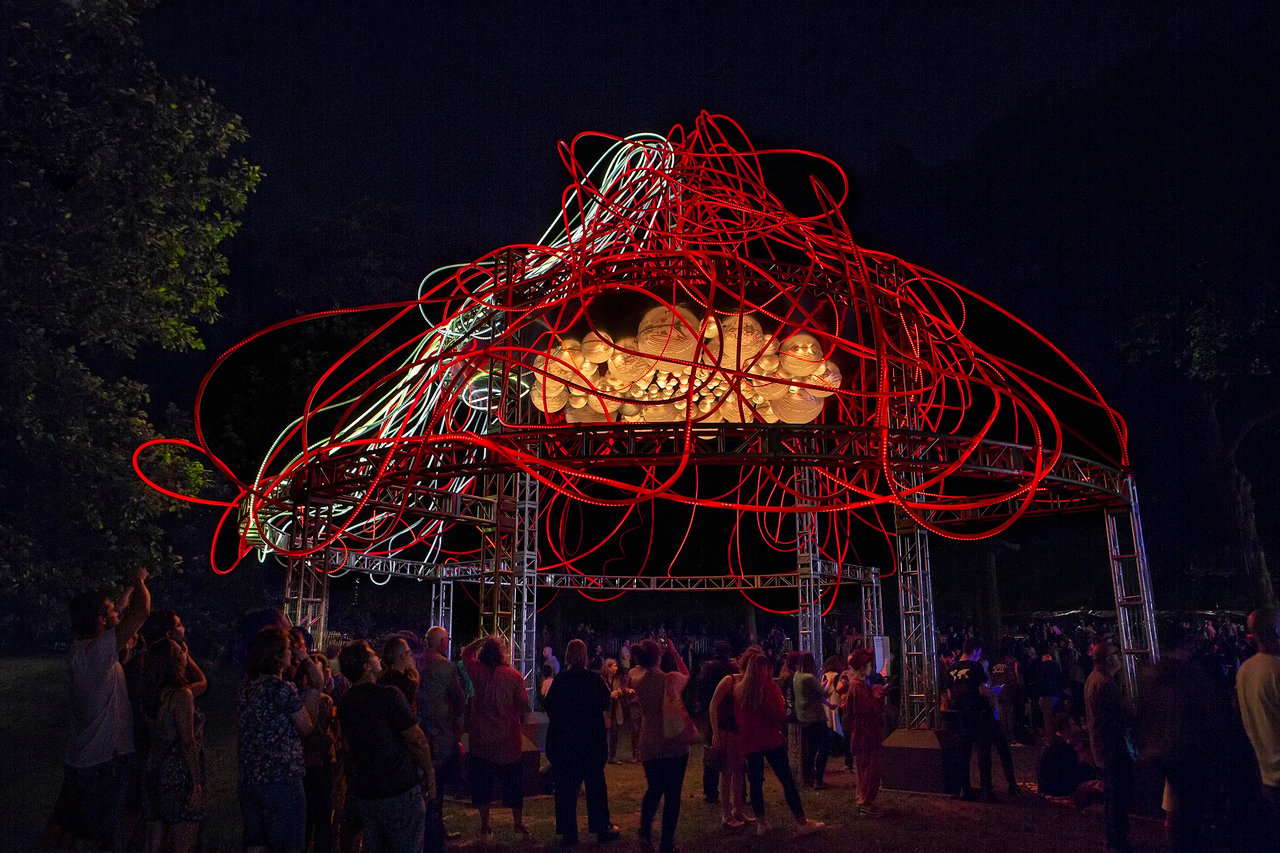 Grimanesa Amorós HEDERA — large-scale outdoor light sculpture and public art light sculpture at the Prospect Park Bandshell, BRIC, Brooklyn, NY. Over 2,000 square feet of glowing ivy-like LED art transitions from translucent white to deep red, while reflective domes shift from aquamarine blue to ruby red. Light sculpture outdoor installation by Grimanesa Amorós.