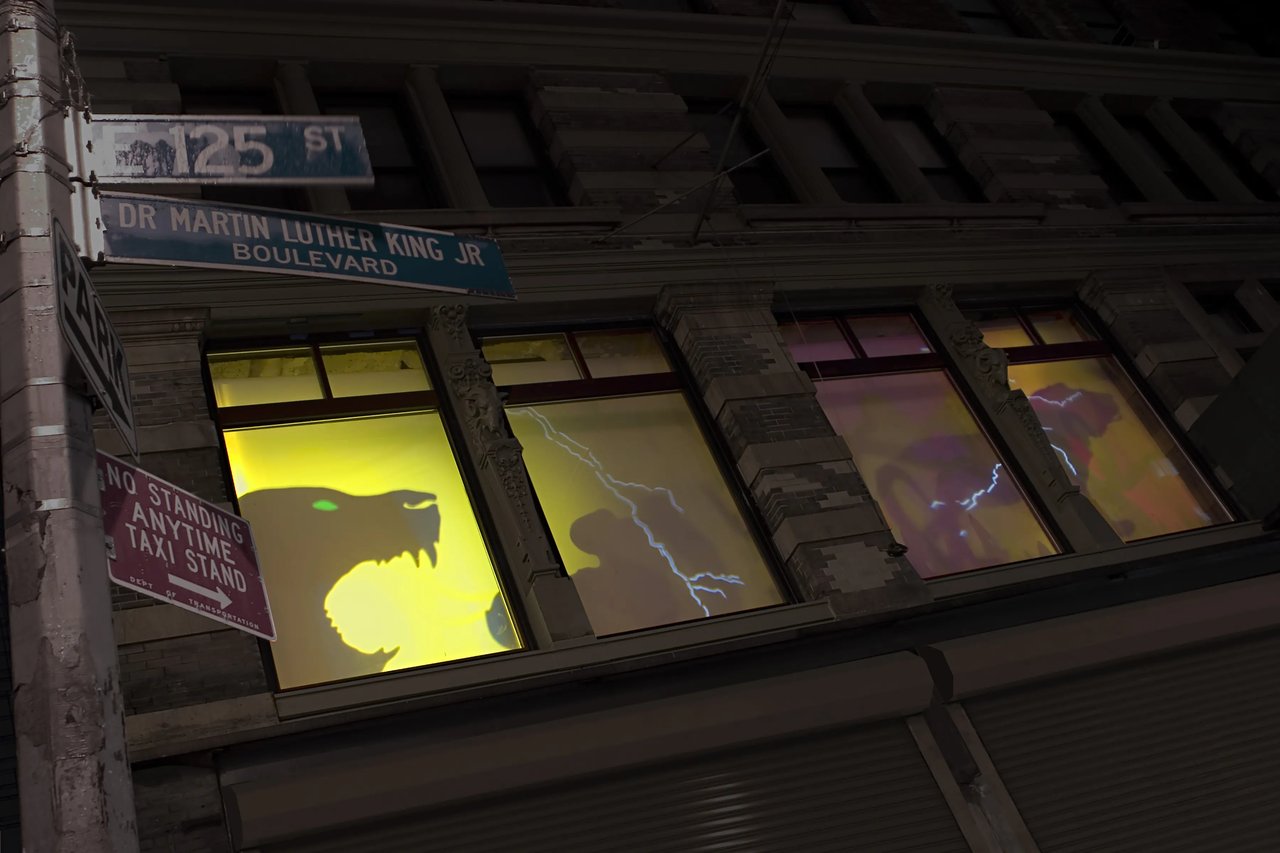 Grimanesa Amorós FRENTE FEROZ, permanent 12 x 53 x 40 2/3 foot public art installation at The Lee Building, 125th Street and Park Avenue, Harlem, New York, 2005. Oversized silhouettes of wild animals are projected in a moving light sequence onto the second story windows, illuminated from dusk to dawn and inspired by Eugene Giscombe's passion for wildlife. Site-specific installation by Grimanesa Amorós.