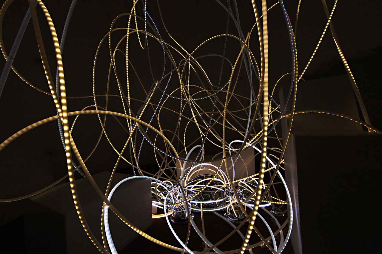 Grimanesa Amorós HUANCHACO, 13 x 15 x 17-foot public art LED sculpture and light sculpture installed inside La Torre de los Vientos, Ruta de la Amistad, Mexico City, 2012. LED light structures woven inside the 40-foot concrete Wind Tower cast an intense play of light and shadow on its tilted surfaces through metal domes, creating an immersive experience that inspires reflection on modern technology and architectural landmarks. Sponsored by Patronato Ruta de la Amistad A.C., Conaculta, World Monuments Fund, and Nina Menocal Gallery. Light sculpture by Grimanesa Amorós.
