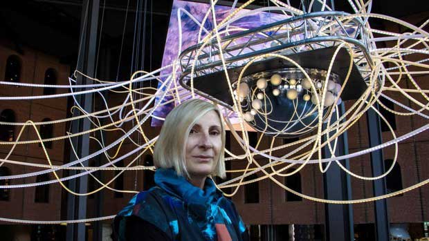 Light Artist Grimanesa Amoros in front of monumental light sculpture scientia